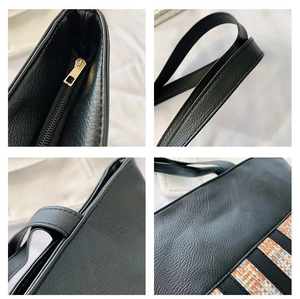Detail view of large black tote bag with gold zipper and colorful woven pattern trim