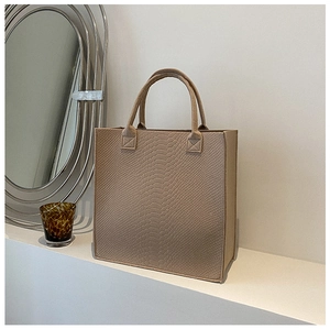 Detailed texture of beige felt tote bag with elegant crocodile embossed pattern