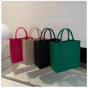 Detail view of felt tote bags with embossed snakeskin texture in four vibrant colors