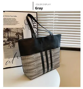 Detail of color-block tote bag with black leather and grey tweed weave texture