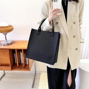 Minimalist black tote bag with crocodile texture pattern for stylish women commuting