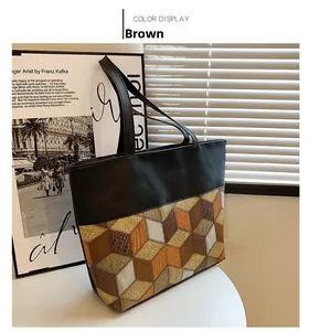 Detail of large tote bag with brown 3D geometric cube pattern and long handles