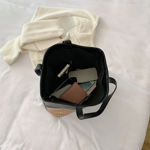 Top view of large black tote bag interior showing ample storage space and textured woven base
