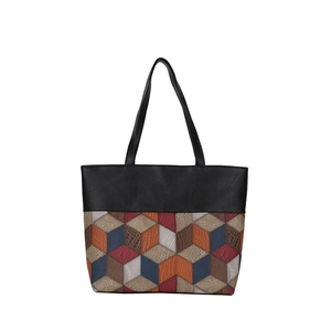 Detail of 3D geometric patchwork on a large tote bag with multi-texture leather panels