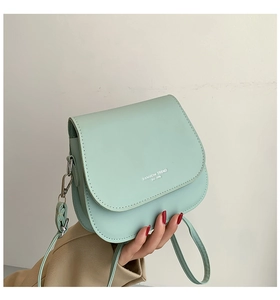 Vue détaillée du sac besace vert menthe avec logo FASHION TREND 1996 et crochets en métal