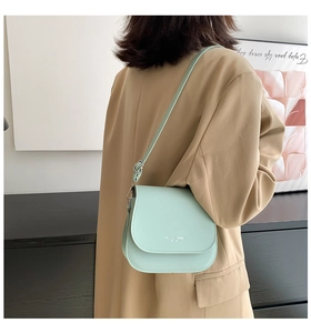 Détail du sac besace vert menthe avec texte Fashion Trend et bandoulière réglable
