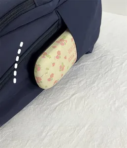 Detail view of the side pocket on the navy nylon backpack holding a glasses case