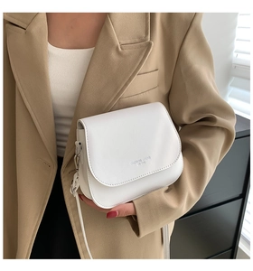 Gros plan du sac bandoulière blanc minimaliste avec logo Fashion Trend sur un blazer