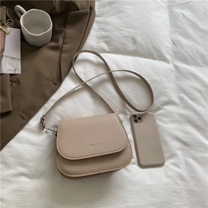 Sac bandoulière beige minimaliste avec lettrage Fashion Trend sur literie blanche