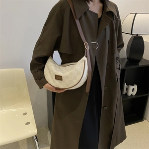 Chic beige checkerboard hobo bag with adjustable leather strap worn by a female model