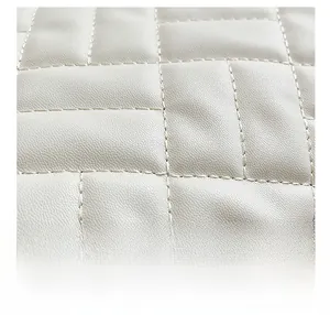 Detailed close-up of premium quilted leather texture and fine stitching on a tote bag