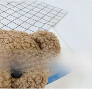 Gros plan détaillé du tissu peluche ours brun montrant la texture de laine d'agneau