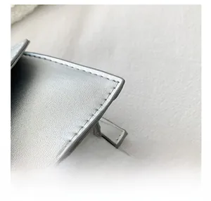 Detail shot of the precise stitching and premium silver-grey leather texture of this mini bag