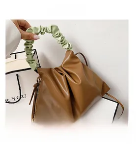 Brown pleated bucket bag with green ruched handle and golden side zipper details