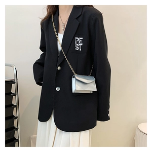 Mini silver chain crossbody bag with metallic finish shown on a blazer for size perspective