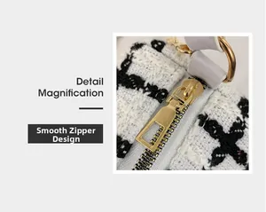 Detail magnification of smooth gold zipper and black and white tweed fabric on handbag