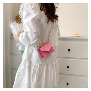 Pink micro envelope crossbody bag with gold chain strap and PU leather texture