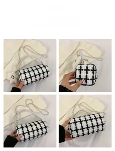 Detail of checkered barrel bag with gold chain and plush bear charm on white handle