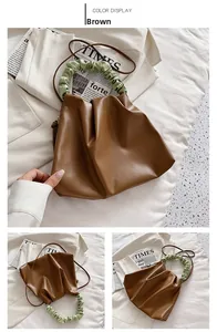 Detail shot of the brown pleated bucket bag featuring a light green cloud-shaped handle