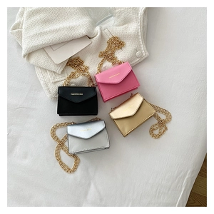 Close-up of four colorful mini envelope chain bags in black pink gold and silver colors