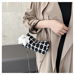 Detail of checkered tweed cylinder bag with gold chain and plush cloud charm