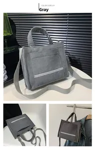 Detail view of a gray corduroy tote bag featuring adjustable strap and front pocket texture