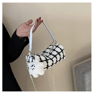 Detail of tweed checkered cylindrical bag with chain strap and cute cloud charm