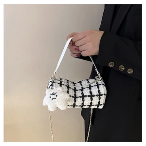 Detail of tweed checkered barrel bag with star charm and metal chain strap