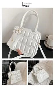 Close-up of quilted white crossbody bag with cookie-grid pattern and mini coin purse detail