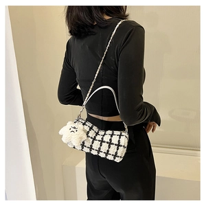 Detail of plaid tweed handbag with white PU strap and star plush charm on shoulder
