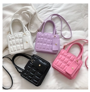 Detail view of quilted crossbody bags in white, purple, black, and pink colors
