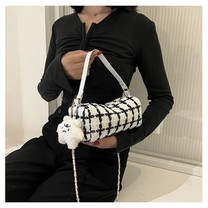 Detail of checkered cylinder mini bag with white leather handle and plush cloud charm