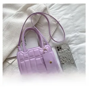 Detail of lavender quilted faux leather handbag with matching mini pouch and strap