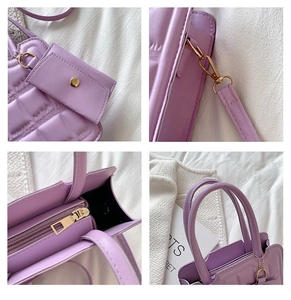 Detail view of purple quilted handbag showing golden hardware and matching mini coin purse