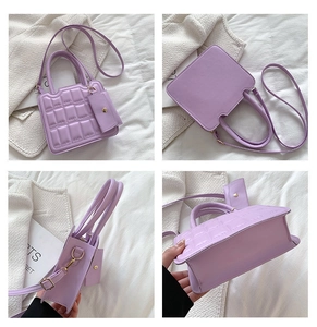 Detail view of light purple quilted handbag with gold hardware and mini pouch charm