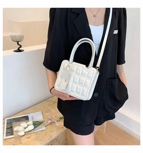 White quilted crossbody bag with dual handles and matching detachable card pouch accessory