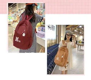 Detail view of burgundy and khaki minimalist backpacks with cute bear charms and logo
