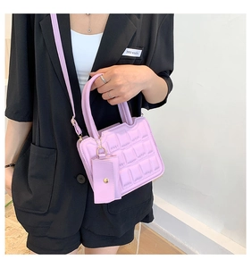Close-up of light purple quilted handbag with matching mini pouch and gold hardware
