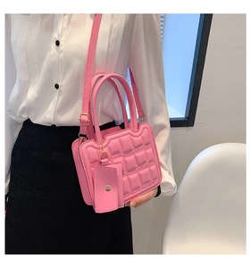 Detail of a bright pink quilted crossbody bag with a matching mini coin purse charm