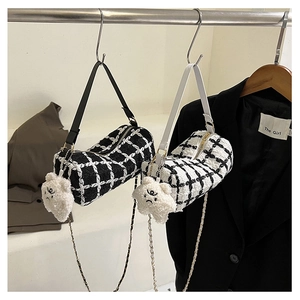 Detail of tweed bucket bags with chain straps and cute star plush charms on a hanger