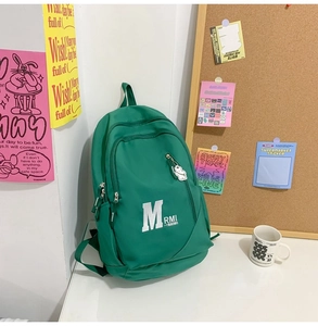 Close-up of bright green vintage school backpack with a cute white bear keychain