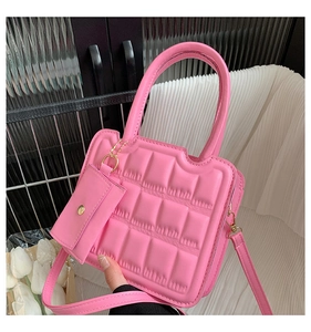 Detail of pink quilted handbag with chocolate block texture and matching mini charm
