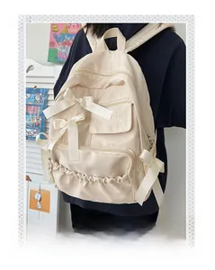 Detailansicht des cremefarbenen Nylonrucksacks für Schüler mit großen Seidenschleifen