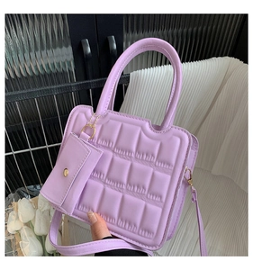 Detailed view of lavender purple waffle texture bag with mini coin purse and gold chain