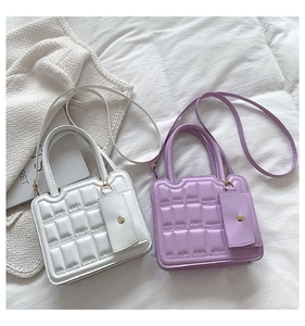 Detail of white and lilac quilted mini bags with texture and small attached pouches