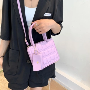 Light purple quilted crossbody bag with matching mini pouch charm and matte PU leather finish