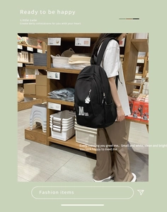 Side view of black vintage school backpack with cute bear charm and large side pockets