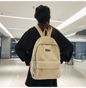 Detail view of a cream minimalist backpack with MRMILID tag and adjustable straps