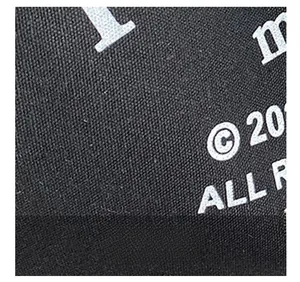 Detailed close-up of premium black canvas fabric with high-density woven texture and print