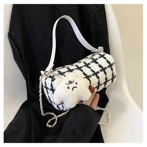 Detail of black and white checkered cylinder bag with cross-stitch and plush star charm